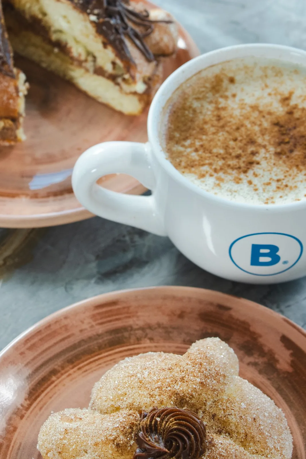 Pan de muerto de churro con cappuccino en Bakings